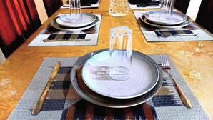 A dining table set with plates, glasses, cutlery, and placemats. - PEACE & QUIET CORNER (Kigali)