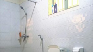 A bathroom with a toilet, a shower, and a window. - PEACE & QUIET CORNER (Kigali)