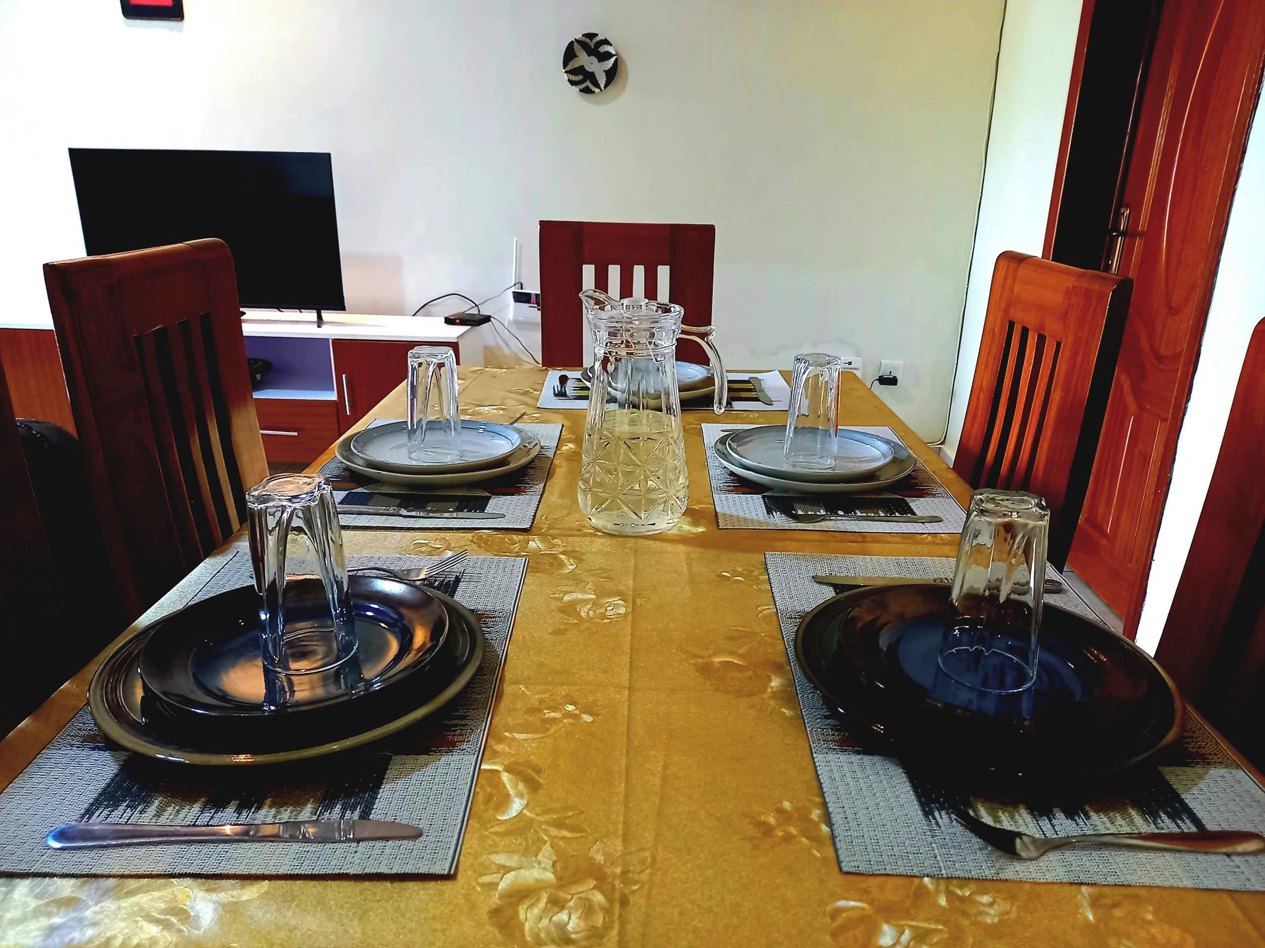 A dining table set with plates, glasses, and cutlery.