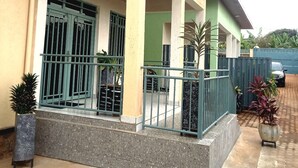 A building with a covered entrance, a gated driveway, and potted plants. - PEACE & QUIET CORNER (Kigali)