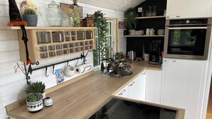 A kitchen with a wooden countertop, a built-in stove, and various kitchen appliances. - Tiny house with terrace, beach chair and garden near Zingst (Pruchten)