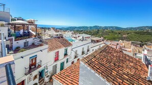 Une terrasse sur le toit offrant une vue sur la mer et les collines.