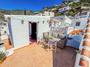A rooftop terrace with a seating area, a small table, and a view of the surrounding neighborhood. - Two bed House With Roof Terrace in the Beautiful Village of Frigiliana (Frigiliana)