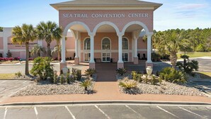 Le centre de congrès Sea Trail, avec sa façade en briques, son entrée en arc de cercle et ses palmiers.