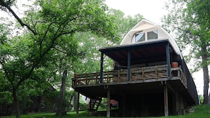 A treehouse with a wooden deck and a small porch.