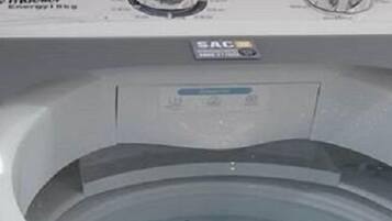 Voorzijde van een wasmachine met bedieningsknoppen en een label dat merk en model aangeeft.