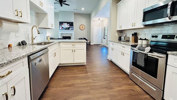 A spacious kitchen with white cabinets, granite countertops, stainless steel appliances, and a central island. - Spacious 3BR Auburn Getaway – Family-Ready and Near All Auburn Has to Offer (Auburn)