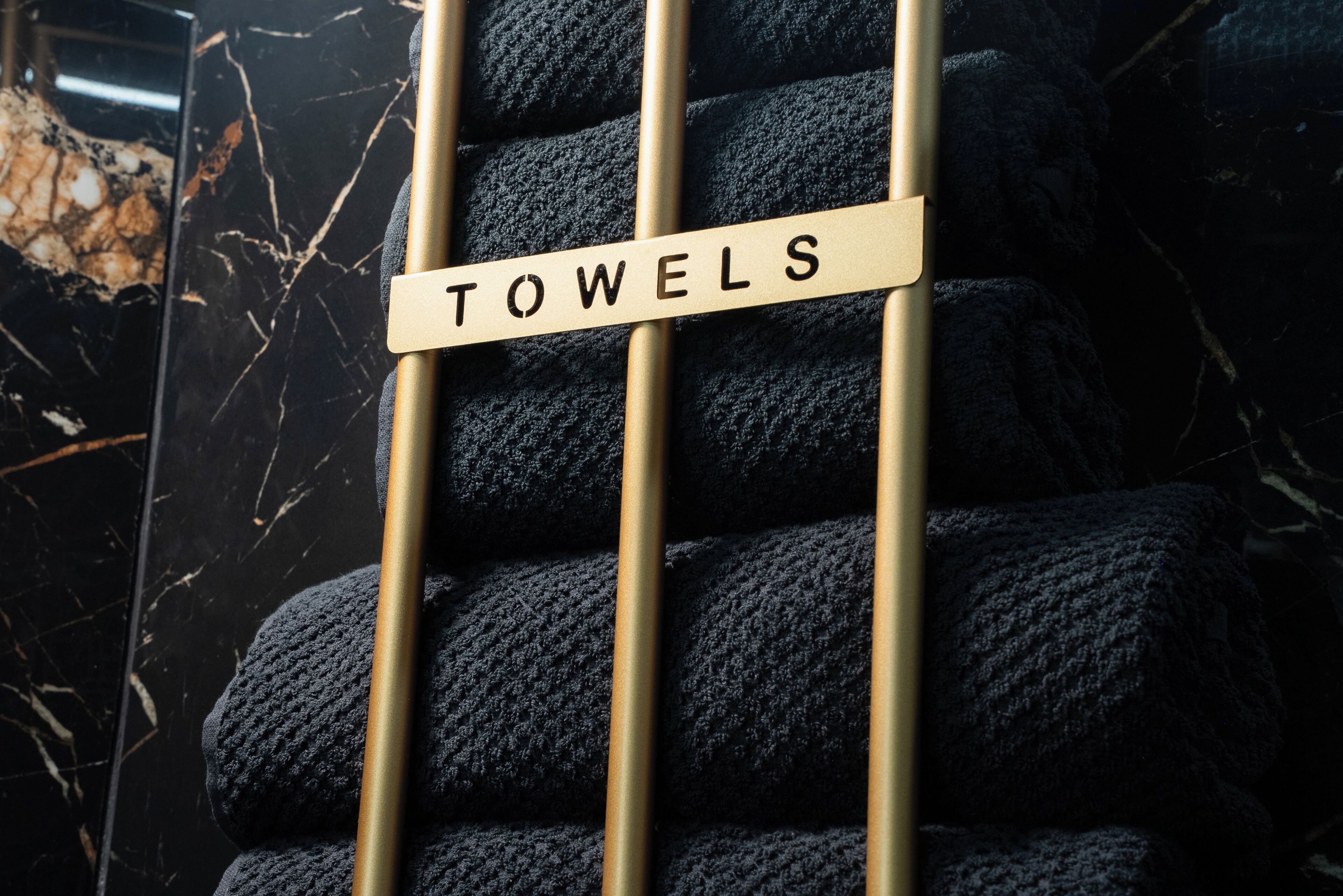 A rack of towels with a sign labeled "TOWELS".