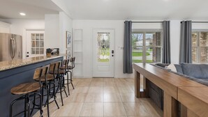 Une cuisine moderne avec un coin bar, une table à manger et un canapé.