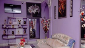 Un salon comprenant un canapé, une table basse et des étagères ornées d’objets décoratifs.