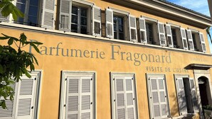 A building with the sign 'Parfumerie Fragonard' and 'Visite de cuisine' indicating a perfume shop and a kitchen visit.