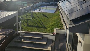 Tagterrasse med basketballbane, havudsigt og solpaneler.