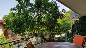 A balcony with a round wooden table and chairs, surrounded by a metal railing. - LODGE ROSA In the pearl of Cilento, cozy studio apartment, Trentova Bay. (Agropoli)