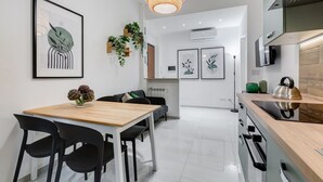 A modern kitchen with white cabinets, a wooden countertop, and a hanging light fixture. - BDC - Green Nrg! 2-BDR free parking (Rome)