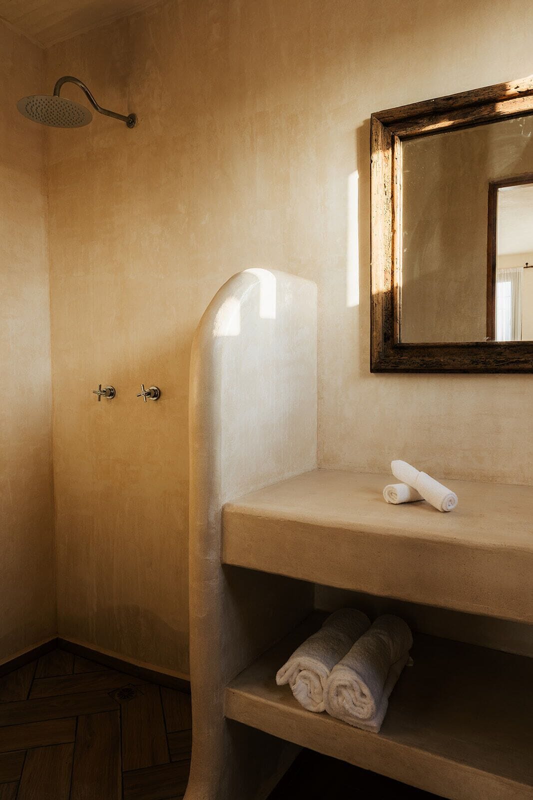 A bathroom with a shower, a sink, and a mirror.