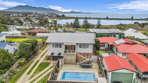 Un quartier résidentiel avec des maisons, une piscine et une vue sur la mer.