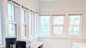 A kitchen with white wooden cabinets, a black coffee maker, and a checkered floor. - Downtown Hagerman Hot Springs Getaway (Hagerman)