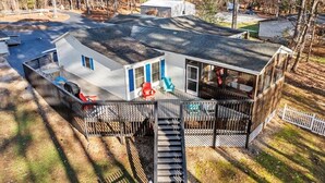 Une cabane dotée d’une terrasse, d’un escalier et d’une cour clôturée.