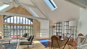 Geräumiges Loft mit hohen Decken, großen Fenstern und modernem Interieur.