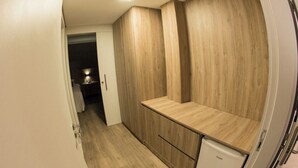 A compact kitchen with wooden cabinets and a small refrigerator. - LARANJEIRAS PALACE HOTEL (Laranjeiras do Sul)