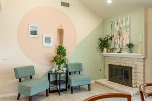 Charming sitting area with fireplace, fresh flowers, and two armchairs — a cozy spot to relax with a book or glass of wine after a busy day at Disneyland. - Huge Backyard, Near Disney, Family Friendly, Quiet Neighborhood (Placentia)
