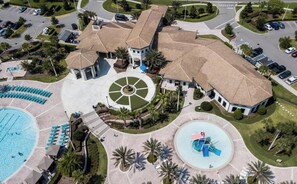A hotel with a central courtyard, a swimming pool, and a circular fountain. - 6-Bedroom Retreat in Champions Gate (Four Corners)