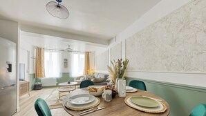 Comedor con una mesa de madera dispuesta para cuatro personas, rodeado de sillas color aguamarina.