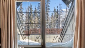 Una ventana con vista a un paisaje nevado y una valla de madera.