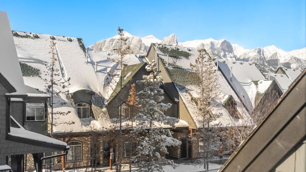 Un pueblo en la montaña cubierto de nieve, con arquitectura singular y un cielo azul despejado.