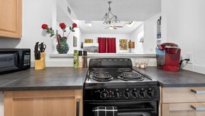 A kitchen with a stove, microwave, and coffee maker.