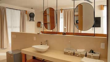 Un baño moderno con un espejo grande, un lavamanos y un ventilador de techo.