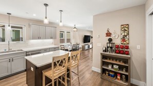 Une cuisine moderne avec un îlot central, des chaises en bois et un coin repas.