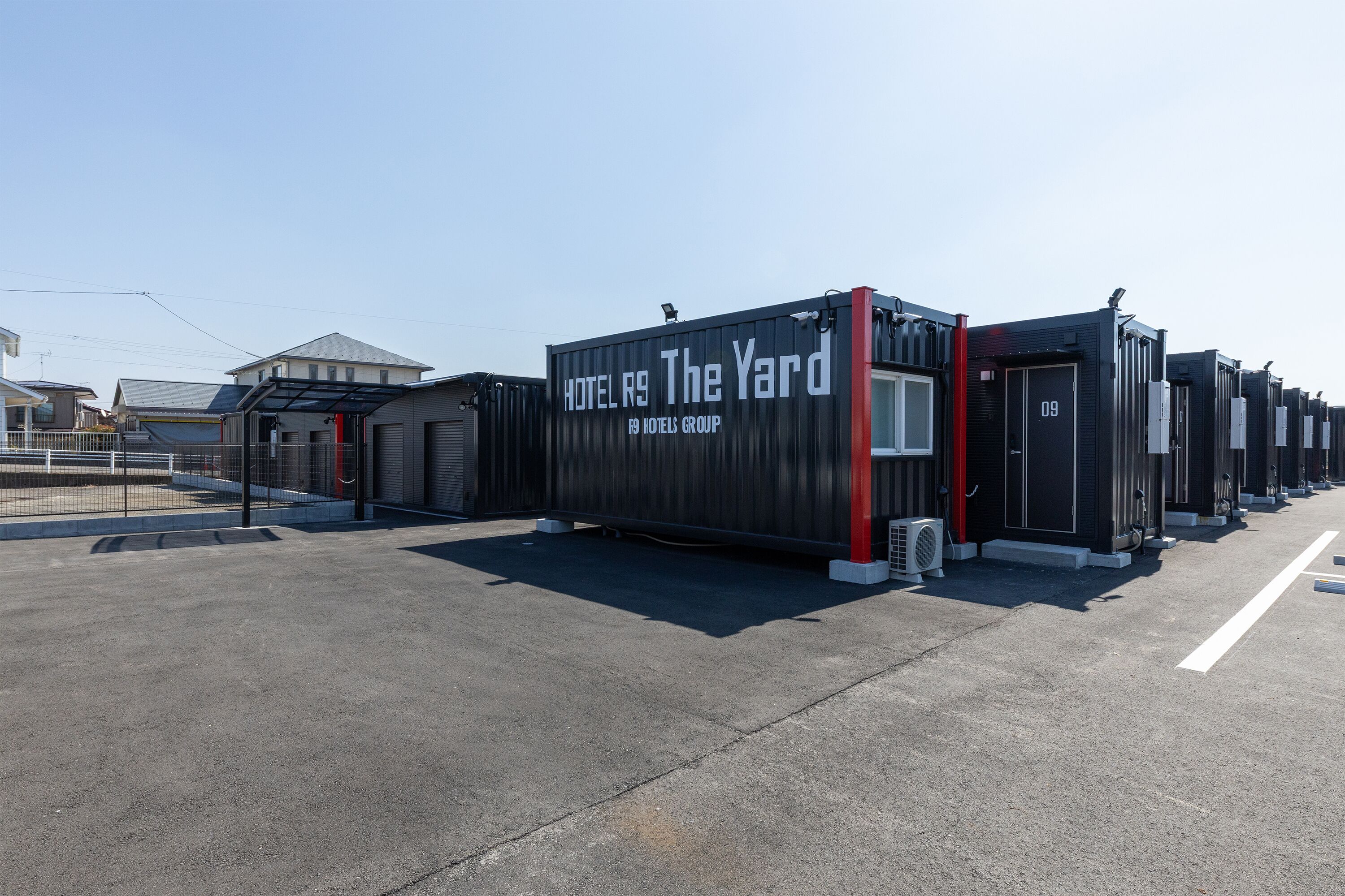 A row of hotel units with a sign reading "HOTEL R9 The Yard" and "HOTEL GROUP".