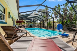 Una piscina scoperta coperta con lettini e una zona ombreggiata.