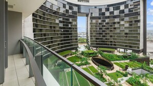 Un bâtiment moderne doté de balcons incurvés et d’une cour intérieure agrémentée de verdure.
