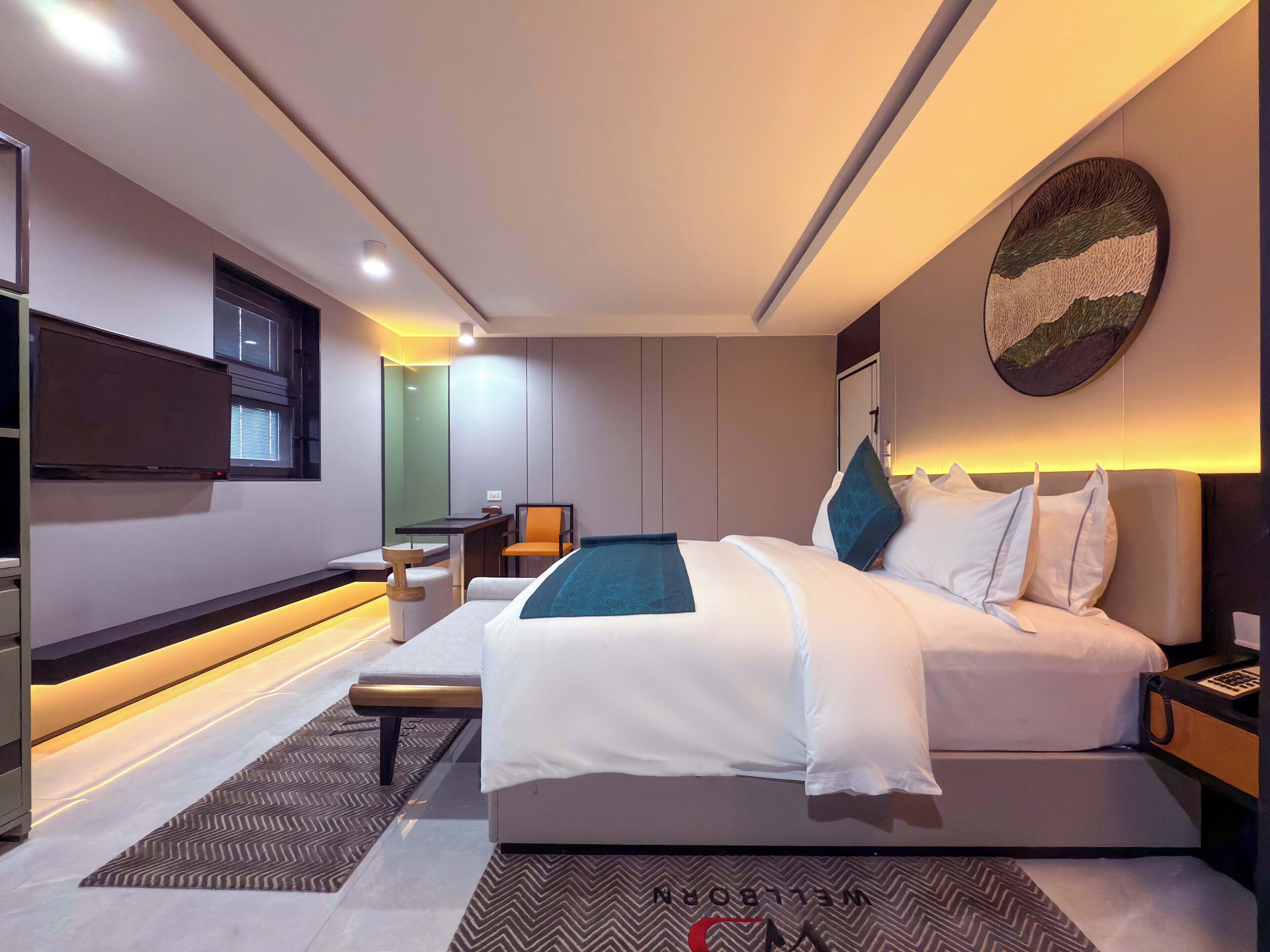 Una habitació d'hotel moderna amb un llit gran, una taula de treball i una cadira.