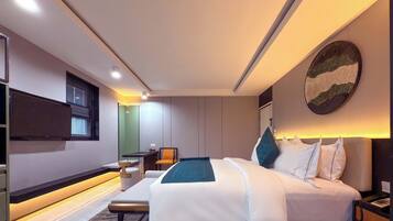 Una habitació d'hotel moderna amb un llit gran, una taula de treball i una cadira.
