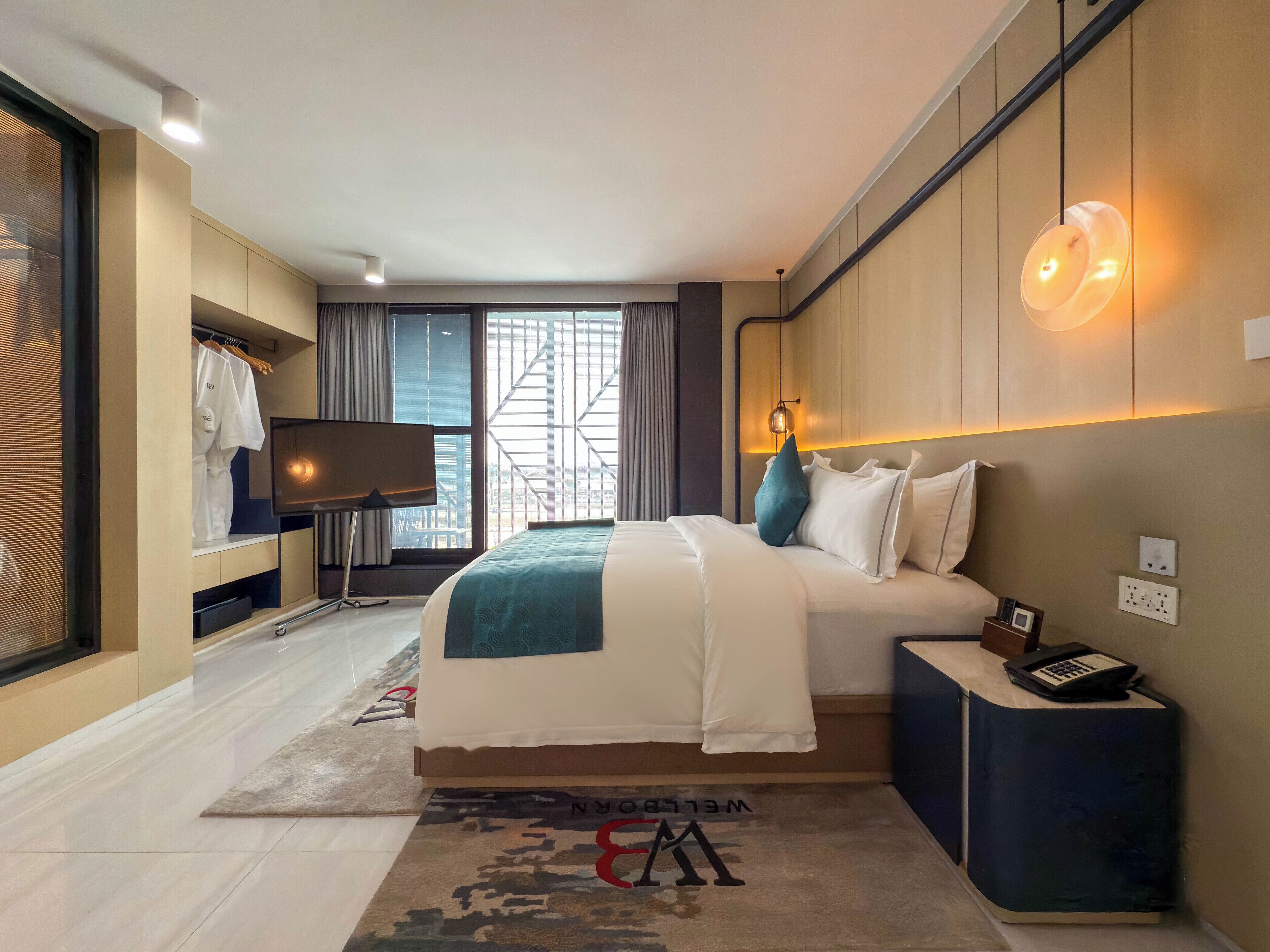 Una habitación de hotel moderna con una cama grande, un escritorio, un armario y vistas a la ciudad.