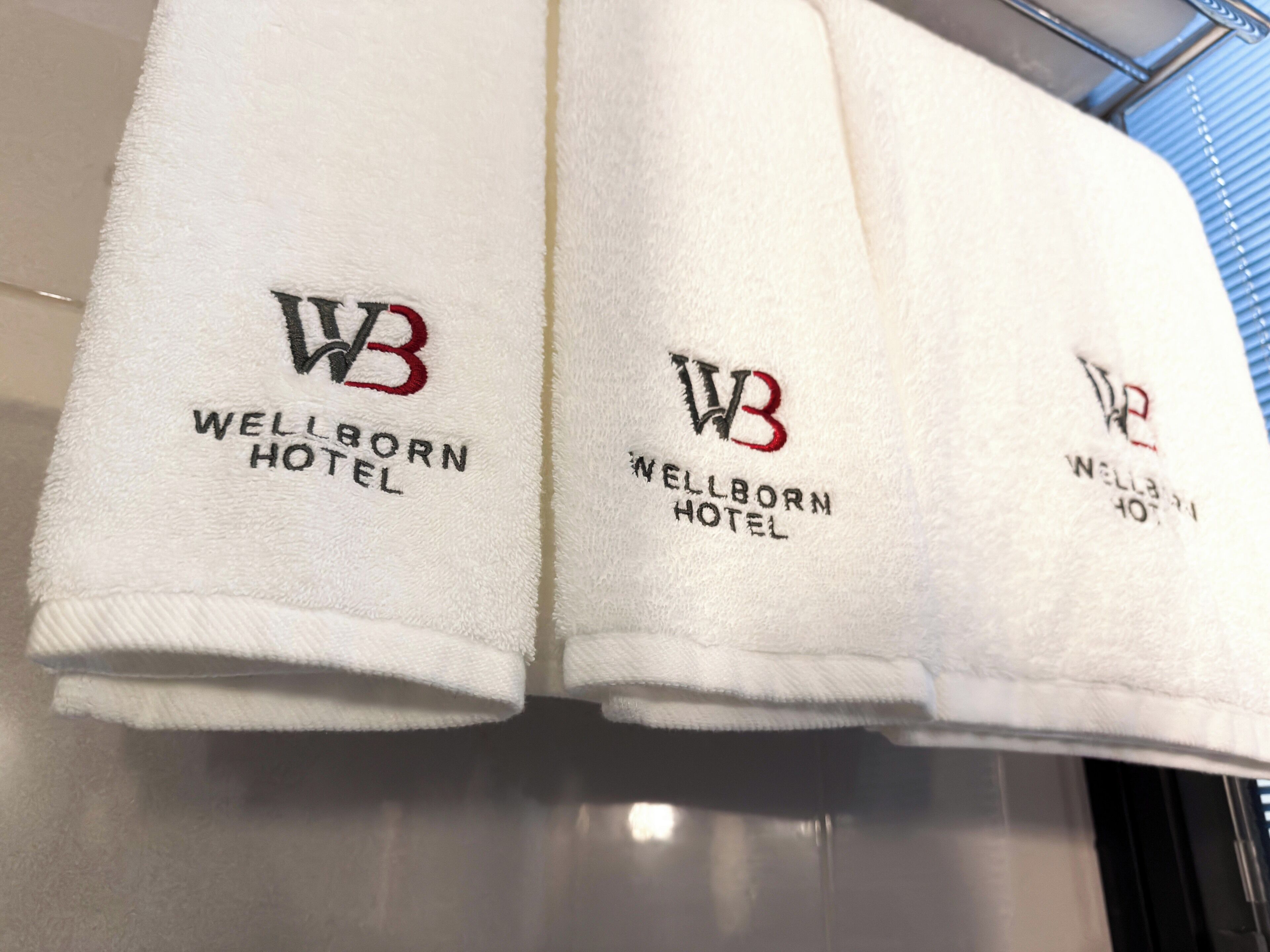 Three towels with the Wellborn Hotel logo and name.