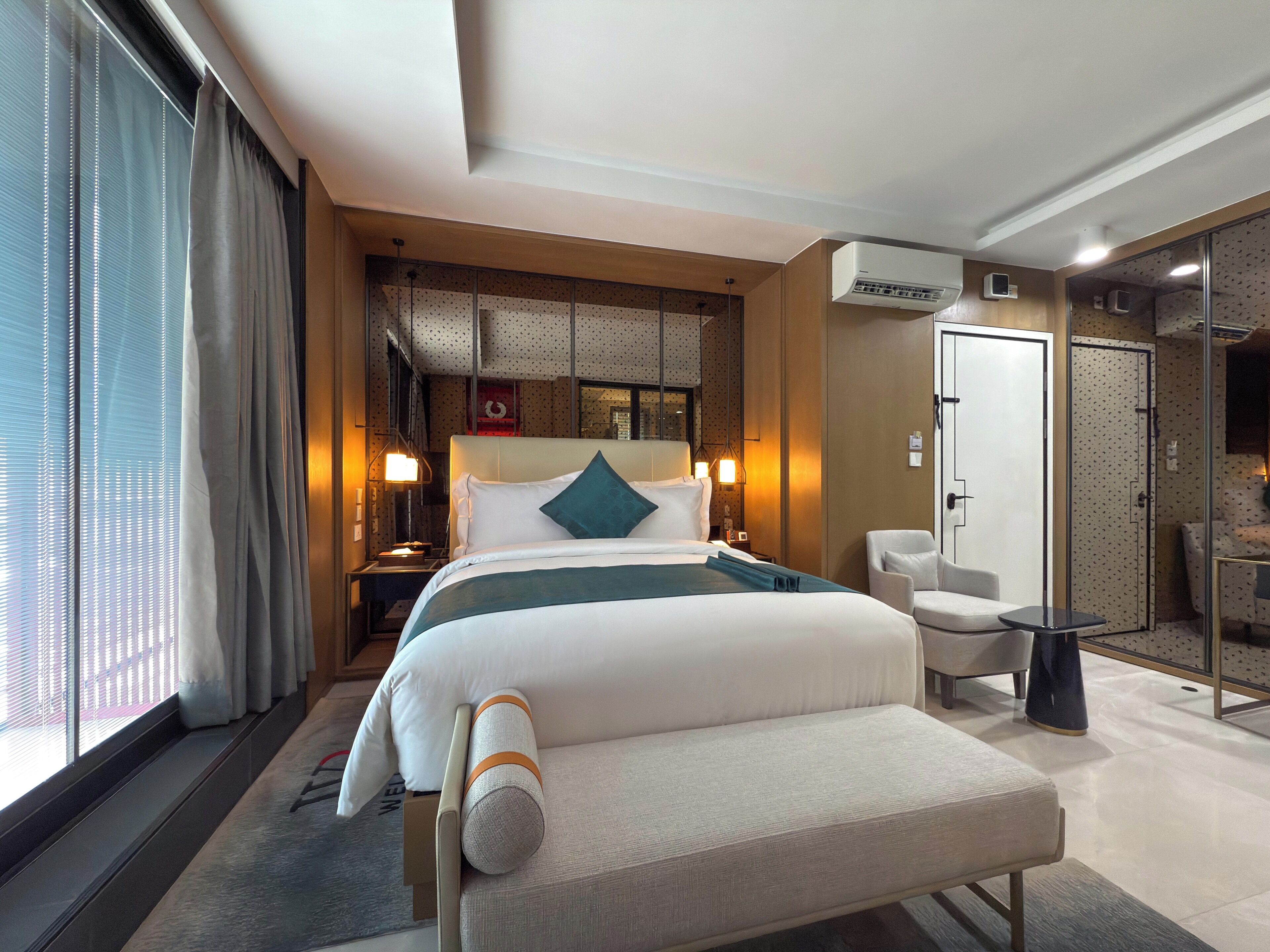 Une chambre d’hôtel avec un lit, une chaise, un bureau et une salle de bain.