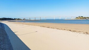 A beach with a long white bridge over water, sandy shore, and clear blue sky. - Proche Océan, forêt et commerces by Interhome (Fromentine)
