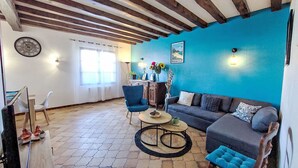A living room with a blue accent wall, a wooden ceiling, a sofa, a coffee table, and a chair. - Proche Océan, forêt et commerces by Interhome (Fromentine)