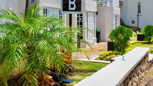 A sign indicating 'BLOCK B' in front of a building with a white exterior and multiple windows. - Falcon CoralReef-Gated-24/7 Security-Airport Transport (Montego Bay)