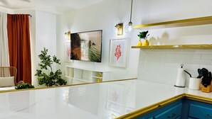 A modern kitchen with white marble countertops, blue cabinets, and a white tiled backsplash. - Falcon CoralReef-Gated-24/7 Security-Airport Transport (Montego Bay)