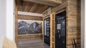 Eine moderne Lobby mit Holzboden, einer Kaffeebar und einer großen, an der Wand befestigten Darstellung einer Berglandschaft.