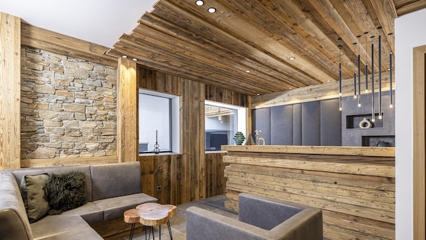 Ein modernes Interieur mit einer Steinwand, Holzboden und einer Bar.