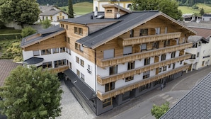 Ein mehrstöckiges Hotel mit hölzernen Balkonen vor einer Bergkulisse.