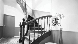 Eine Treppe mit aufwendiger Balustrade und einer dekorativen Metallskulptur.