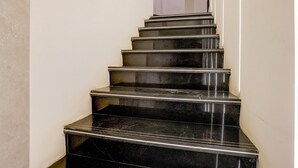 Un escalier en marbre noir menant à un palier.