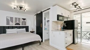 A modern bedroom with a bed, bedside table, and a wardrobe. - Aloha Suite Near the Sea IV, 3 Block Walk to Beach (Honolulu)